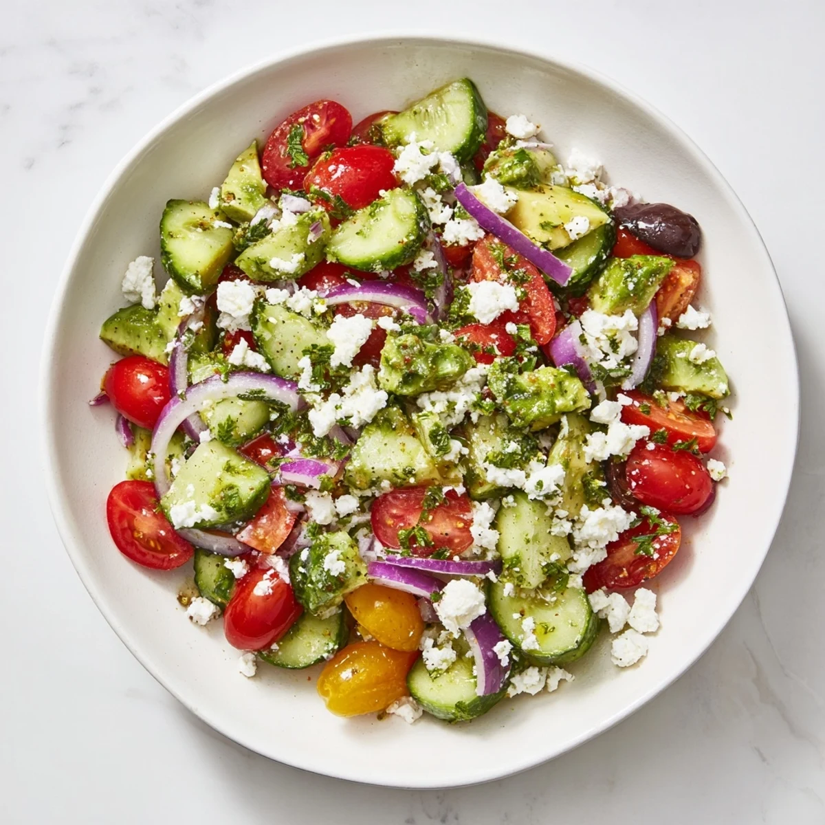 This Fresh Cucumber, Tomato, and Avocado Salad features ripe tomatoes mingling with cool cucumbers.