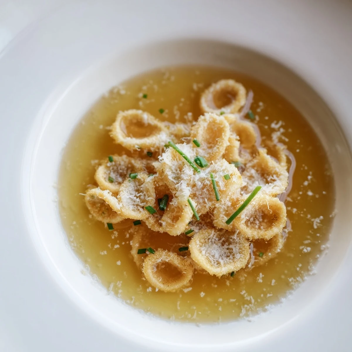 Golden, crispy pasta chip cereal presented, swimming in a warm, savory parmesan broth, ready to eat.