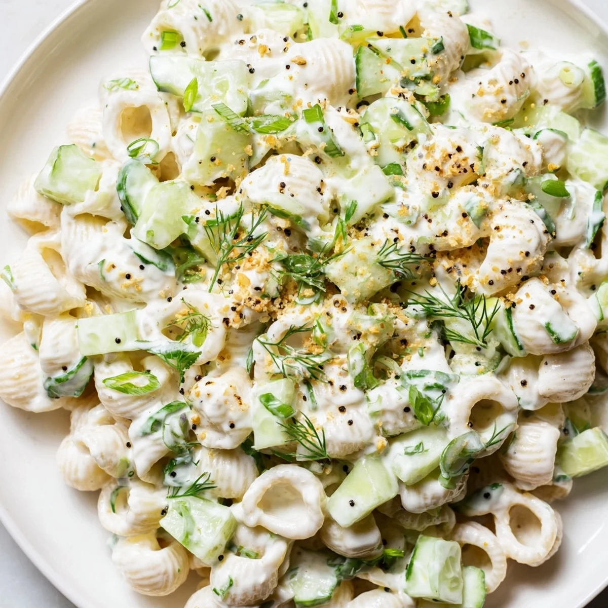 A close-up of creamy Cucumber Crunch Pasta Salad with diced cucumbers and everything bagel seasoning, served as a refreshing vegetarian side.