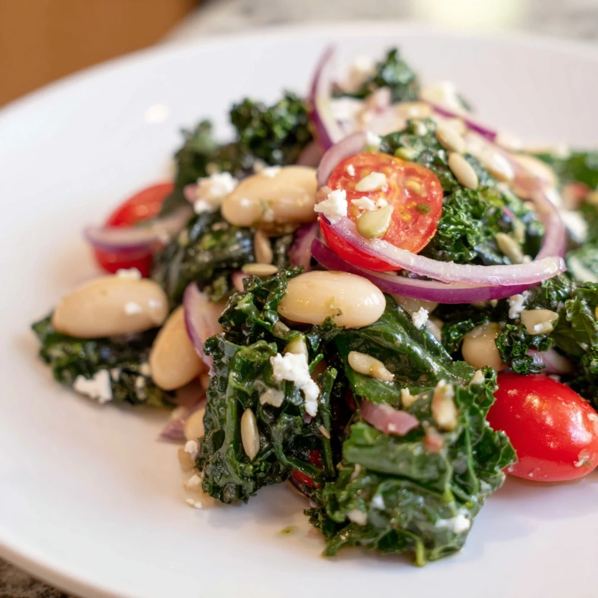 A close-up of a vibrant White Bean and Kale Salad, featuring massaged kale, creamy white beans, and halved cherry tomatoes tossed in a lemon-garlic dressing.