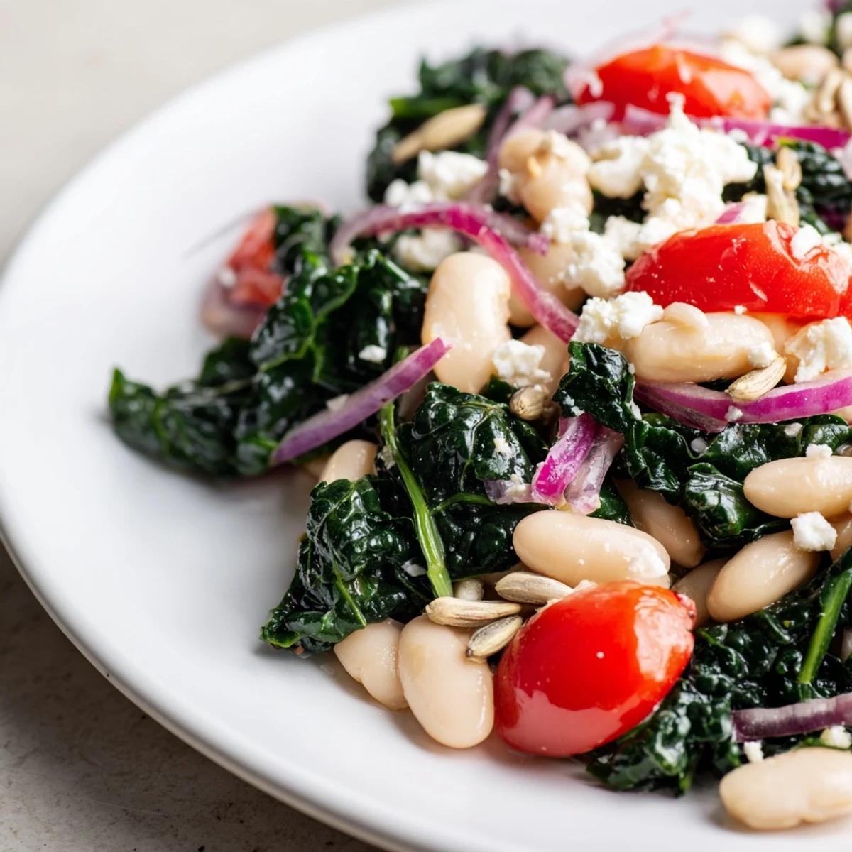 This White Bean and Kale Salad is served in a rustic bowl, topped with sunflower seeds and crumbled feta, perfect for a healthy Mediterranean lunch.