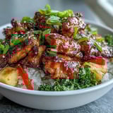 Savory glazed chicken and crisp vegetables over fluffy rice, garnished with scallions and fresh pineapple.