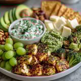 Festive St. Patrick's Day green food board with fresh fruits, veggies, and savory snacks arranged for a vibrant celebration spread.  