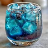 Color-changing butterfly pea flower lemonade transforms from blue to purple when mixed with fresh lemon juice and ice.