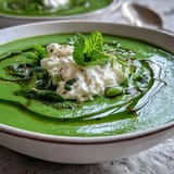Bright green spring pea soup topped with dollops of fluffy ricotta, invitingly fresh.