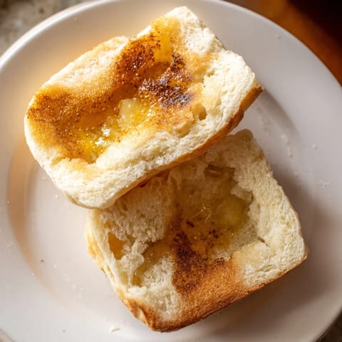 Warm, buttery sheet pan English muffins, pulled apart to reveal their airy, delicious insides.