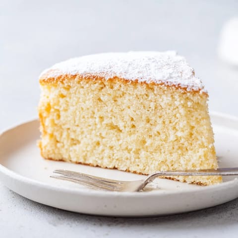 A fluffy Simple 3-Ingredient Vanilla Sponge Cake, golden-brown and ready to be frosted.