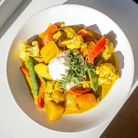 Enjoy this hearty Waste-Free Vegetarian Curry, served with vibrant, fresh cilantro and fluffy rice.