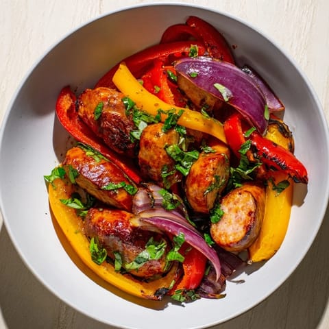 Golden-brown Italian sausages atop a bed of caramelized peppers and onions, from this easy sheet pan recipe.
