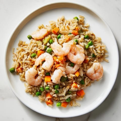 Golden-brown Shrimp Garlic Fried Rice sizzling in a wok, releasing aromatic garlic and soy sauce steam in a cozy kitchen setting.