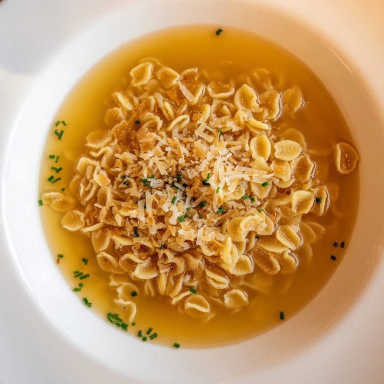 A close-up of pasta chip cereal: crunchy little chips in a creamy parmesan broth for a unique snack.