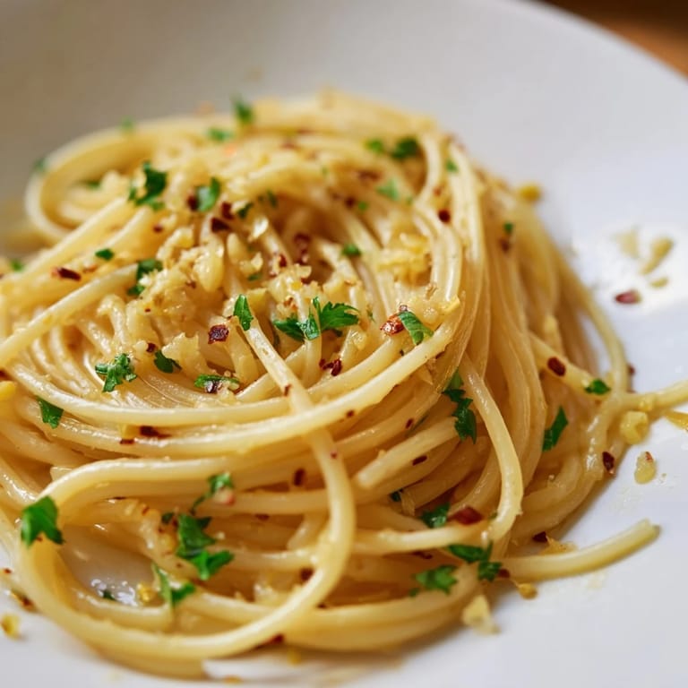 Quick and easy Aglio e Olio Express Pasta ready to eat, garnished with fresh parsley and Parmesan cheese.