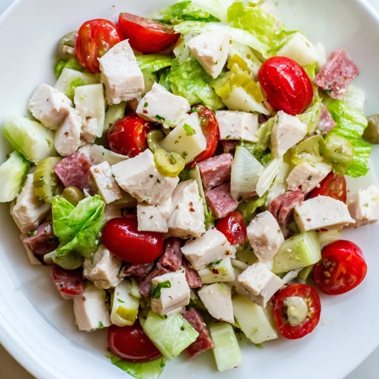 Italian Deli Chopped Chicken Salad tossed in a tangy herb vinaigrette, featuring juicy tomatoes, red onion, and cucumbers.